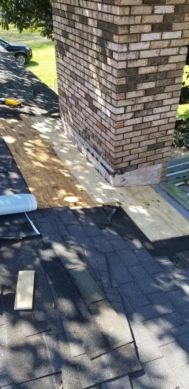 New plywood decking installed around brick chimney